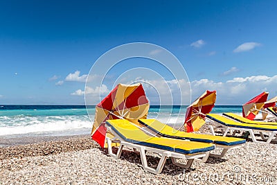 Eye catching parasols lying on picturesque pebble Mediterranean Stock Photo
