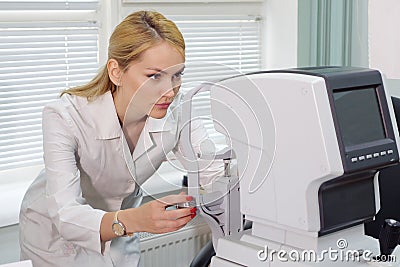 Eye doctor woman with ophthalmologic device in the cabinet Stock Photo