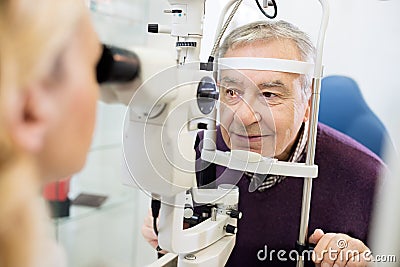 Eye specialist determines distance of eyes pupil to patient Stock Photo