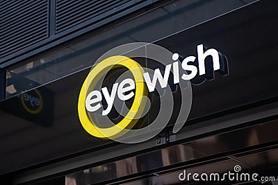 Eye Wish Opticien store, with illuminated shop logo. Editorial Stock Photo