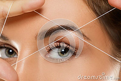 Eyebrow threading - epilation procedure for brow shape correction Stock Photo