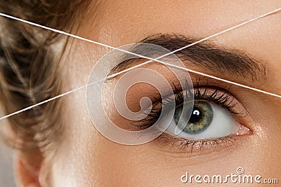 Eyebrow threading - epilation procedure for brow shape correction Stock Photo