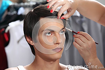 Eyebrows with makeup brush, model at mirror in dressing room Stock Photo