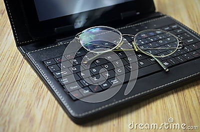 Eyeglass and laptop computer on wooden background Stock Photo