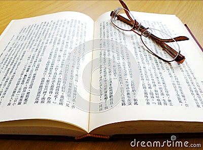 Eyeglasses on chinese book Stock Photo