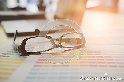 eyeglasses, color swatch on office desk. graphic designer workspace. creative design work. business workplace concept. Stock Photo