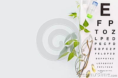 Eyeglasses, contact lenses, vitamins and Snellen table with copy space Stock Photo