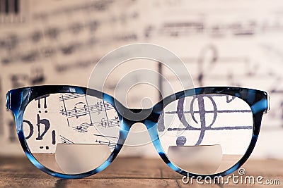Eyeglasses Glasses with Bifocals and Black blue Frame smudged agaist musical note sheet. Blurry Vision Concept Stock Photo