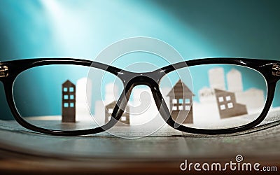 Eyeglasses lie on the open newspaper with paper houses Stock Photo