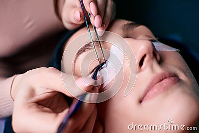 Beautiful Woman with long eyelashes in a beauty salon. Eyelash extension procedure. Lashes close up Stock Photo