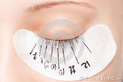 Eyelash extension procedure. Master marker puts markup scheme guide lashes Stock Photo