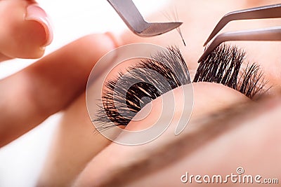 Eyelash Extension Procedure. Woman Eye with Long Eyelashes. Lashes, close up, macro, selective focus. Stock Photo