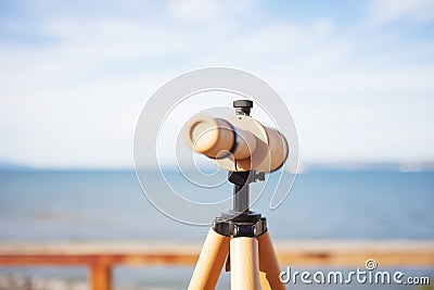 eyepiece of a wooden telescope against the ocean view Stock Photo