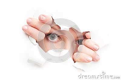 Eyes of woman peeking through a hole torn in white paper poster Stock Photo