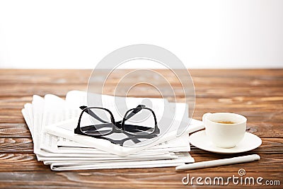 eyesight, cup of coffee, digital tablet and pile of newspapers on wooden surface Stock Photo