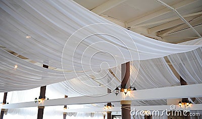 Fabric drape on the restaurant ceiling. Bright interior, lighted lantern. The decor for the wedding party Stock Photo