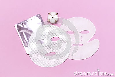 Fabric face mask, cotton flowers on pink background. Concept of natural cosmetics, face care, spa, face cream, women`s beauty Stock Photo
