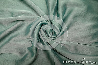 Fabric light gray spread out on the table and slightly twisted. Stock Photo