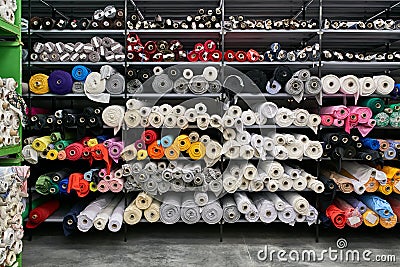 Fabric warehouse with many multicolored textile rolls Stock Photo