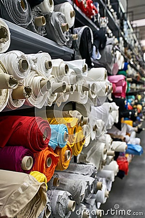 Fabric warehouse with many multicolored textile rolls Stock Photo