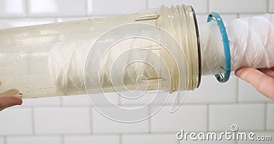 Fabric water filter for water. Man inserts a clean cartridge into the flask. Close-up, first-person view. Stock Photo