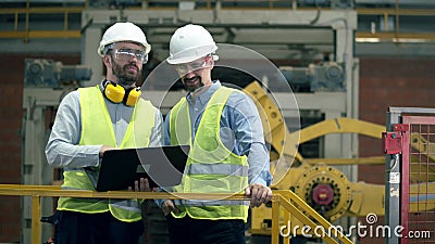 Fabrieksingenieurs in een moderne fabriek De moderne industriële fabrieksarbeiders gebruiken laptop stock footage Fabrieksingenieurs in een moderne fabriek De moderne industriële fabrieksarbeiders gebruiken laptop stock footage