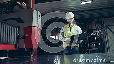 Fabrieksmedewerker kijkt naar laserapparatuur die metaal snijdt Professionele zware technicus stock video Fabrieksmedewerker kijkt naar laserapparatuur die metaal snijdt Professionele zware technicus stock video