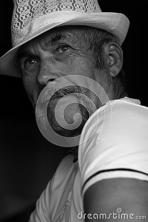 Fabulous at any age concept. Close up portrait of handsome mature man with moustache in white shirt and hat. Stock Photo