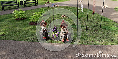 Fabulous funny gnomes made of burnt clay sitting on wooden stumps Stock Photo