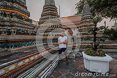 Fabulous, mystical, Buddhist Asian temple. Tourist on vacation. A man walks around the ancient pagodas. Wat Pho in Stock Photo