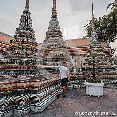 Fabulous, mystical, Buddhist Asian temple. Tourist on vacation. A man walks around the ancient pagodas. Wat Pho in Stock Photo