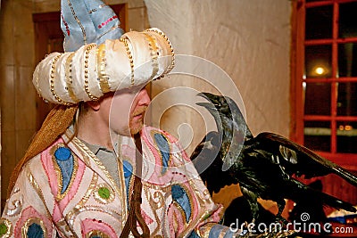 A fabulous wise man beautifully dressed in silk. Eastern dervish, a scientist with the black hand the Raven Editorial Stock Photo