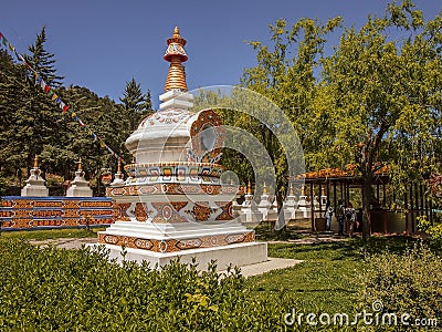 Facade of a beautiful colorful Buddhist temple with green trees and tourists Stock Photo