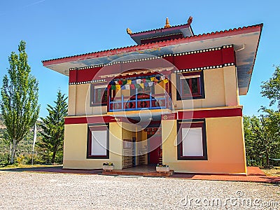 Facade of a beautiful colorful Buddhist temple among green trees under a blue sky Stock Photo
