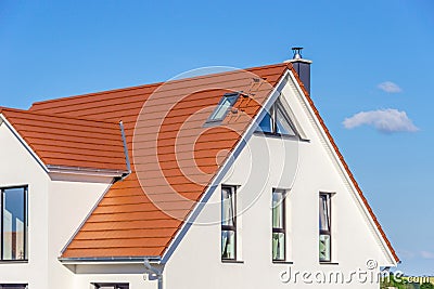 Facade of a modern house with red tiled roof, blue sky Stock Photo