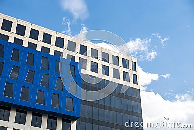 A modern office building agaisnt a partially cloudy sky. Contemporary design of office building in BPO industry. Stock Photo