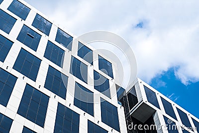 A modern office building agaisnt a partially cloudy sky. Contemporary design of office building in BPO industry. Stock Photo