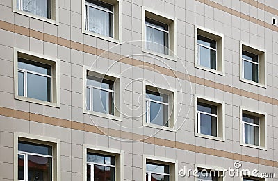 The facade of a multi-storey clinical building. The walls with many windows are finished with plastic Stock Photo