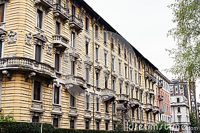 Facade of an old house with carved stone balconies and stucco moldings. Milan, Italy Editorial Stock Photo