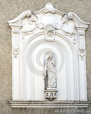 The facade of an old house with niche and sculpture of the Virgi Stock Photo