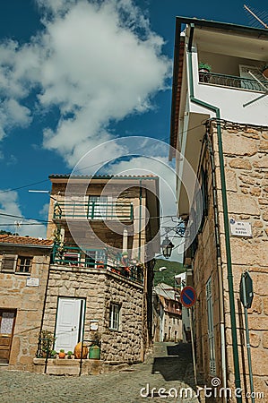 Facade of old houses with stone wall and signpost Editorial Stock Photo