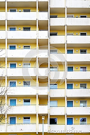 Facade of an old large high-rise apartment building with yellow walls and white balconies, concept for housing and real estate Stock Photo