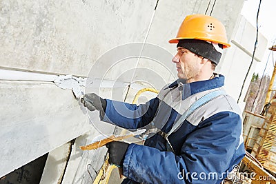 Facade plasterer sealing joint of building wall with putty mastic Stock Photo