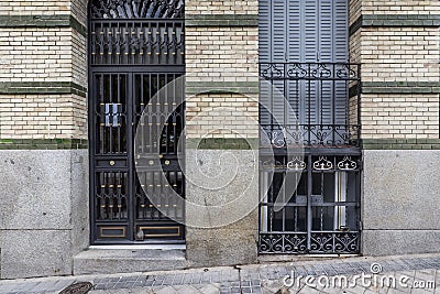 Facade of a residential building with granite blocks on the ashlars and black metal portal and bars on the windows Stock Photo