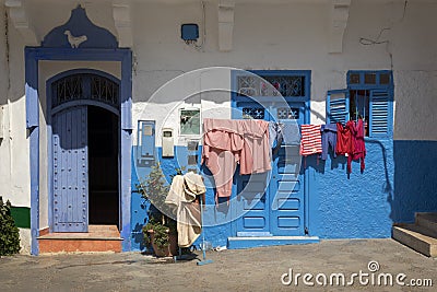 Facade of a traditional house with laundry hanging outdoors in the medina of Assilah Stock Photo