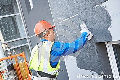 Facade worker plastering external wall of building Stock Photo