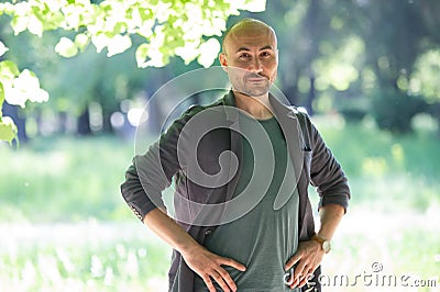Face of a bearded serious bald man in the park Stock Photo