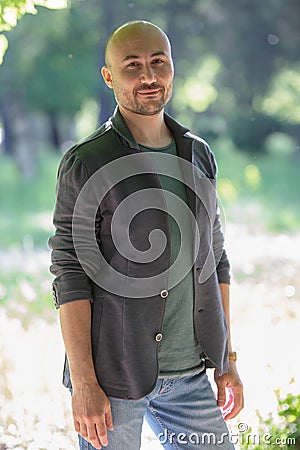 Face of a bearded serious bald man in the park Stock Photo