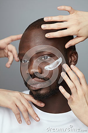 Face Beauty Treatment For Man. Male Face Skincare Routine. Female Hand Applies Cosmetology Cream. Stock Photo