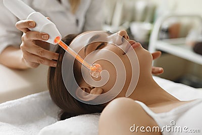 Face Beauty Treatment. Woman Using Darsonval Skin Care Device Stock Photo